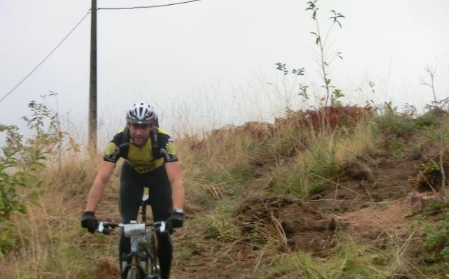 hombre con casco montando en bici por un paraje natural